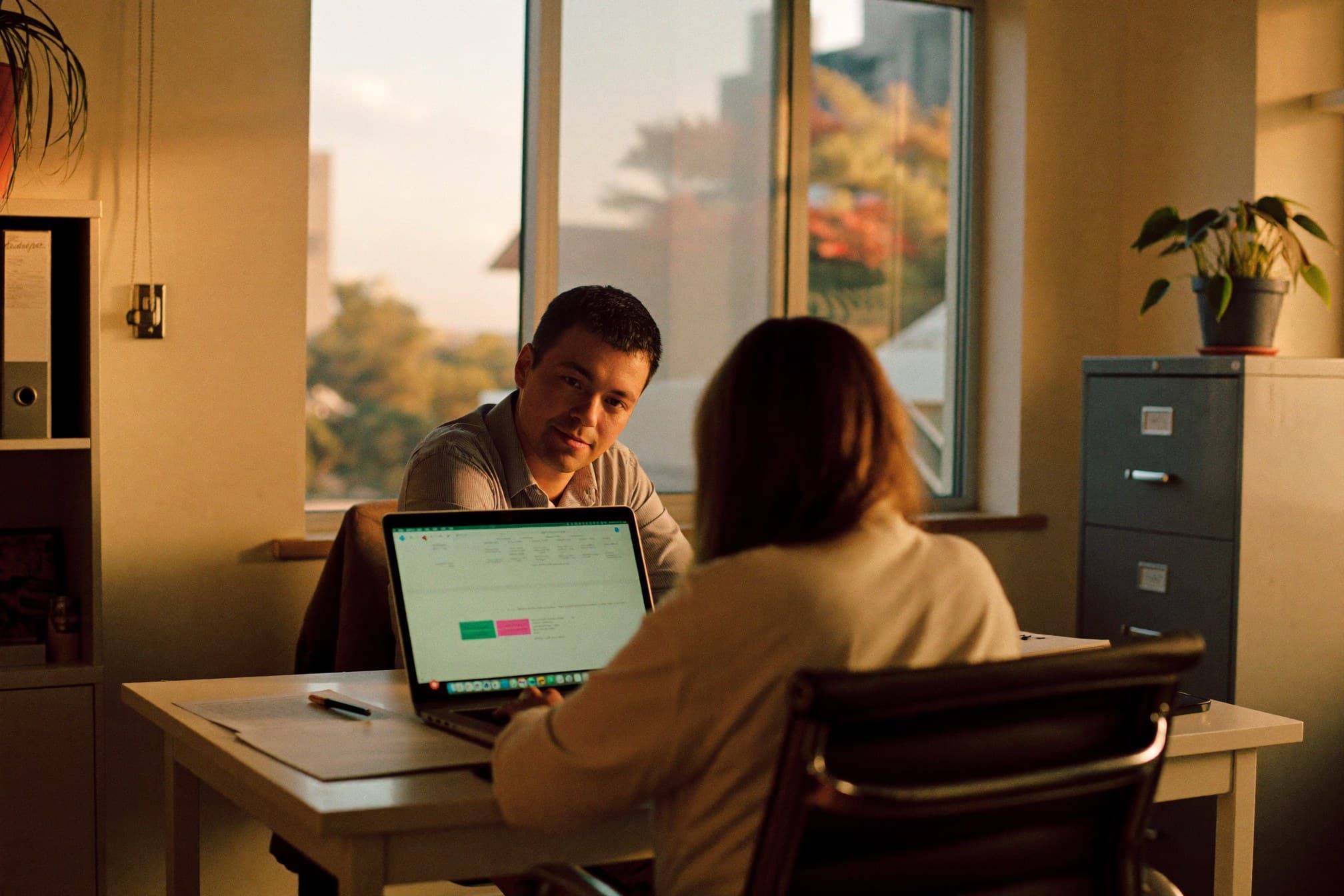 Dos personas revisando juntas la pantalla de una laptop